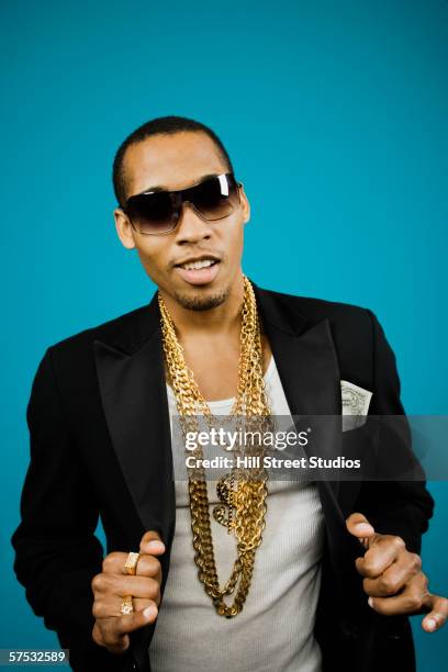 young man wearing large gold chains and sunglasses - bling bling fotografías e imágenes de stock