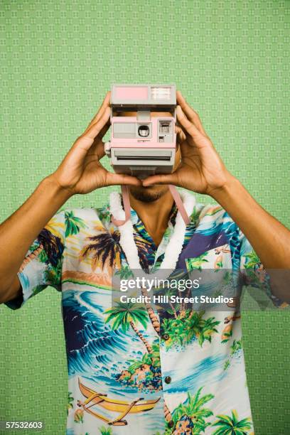 young man taking a polaroid - photography studios stockfoto's en -beelden