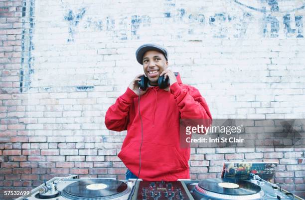 teenage boy using turntables and headphones - dj stockfoto's en -beelden