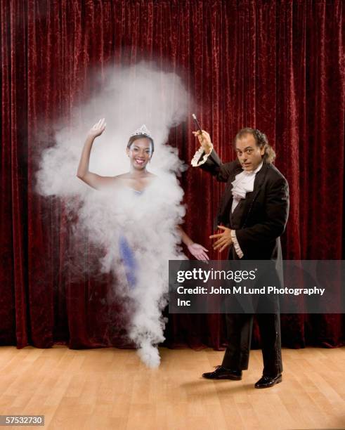magician making woman appear out of thin air - magician disappear stock pictures, royalty-free photos & images