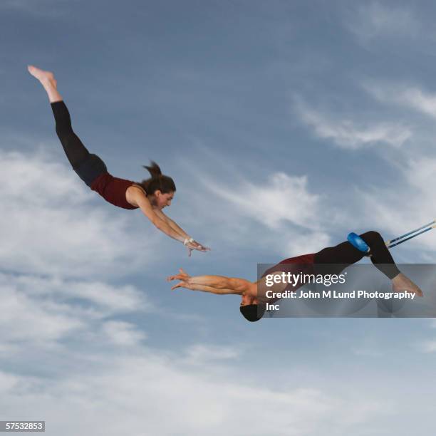 acrobats catching each other in the air - trapeze ストックフォトと画像