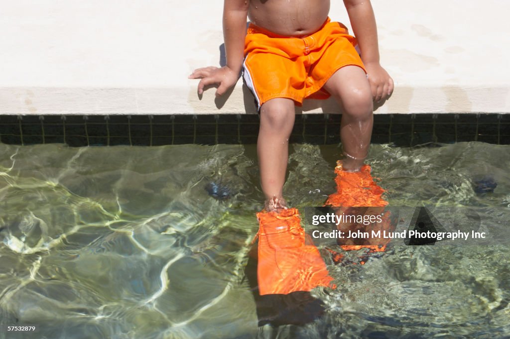 Young boy wearing flippers in a swimming pool