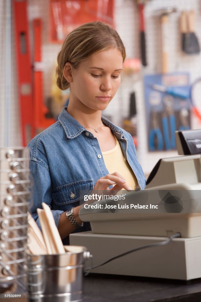 Young woman operating a cash register