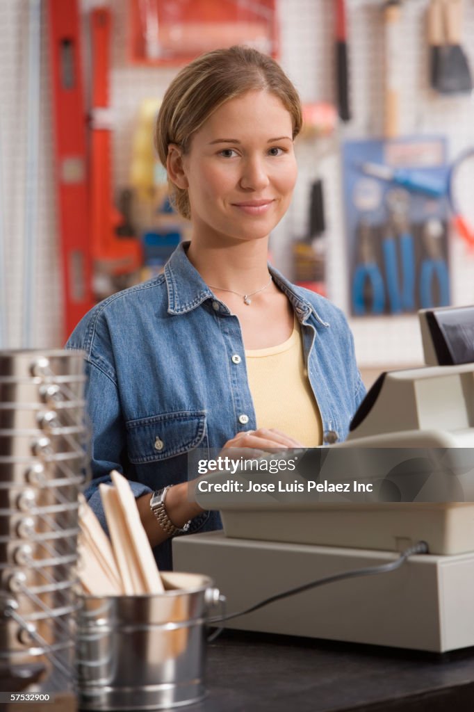 Young woman operating a cash register