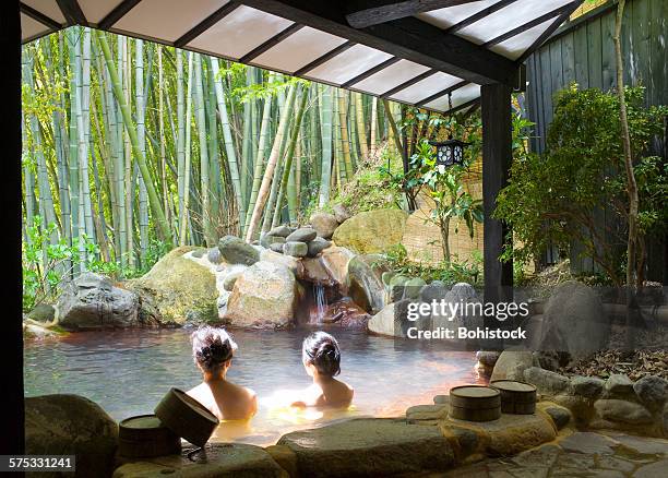 women bathing at hot spring resort - sorgente foto e immagini stock