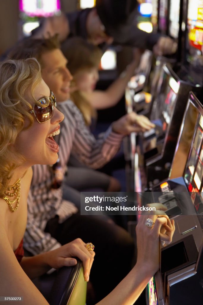 Young woman playing the slot machines in a casino