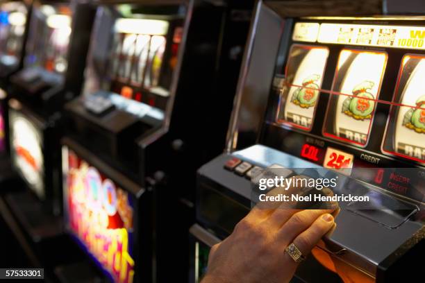 man pushing the spin button on a slot machine - fruit machine stock pictures, royalty-free photos & images