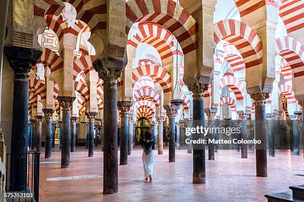 woman walking inside the mezquita, cordoba, spain - mezquita stock pictures, royalty-free photos & images