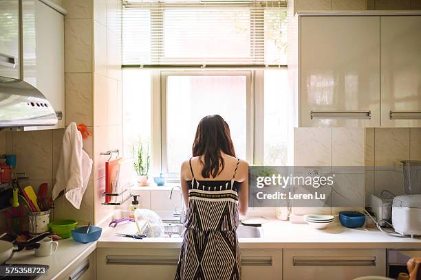 teenage girl washing dishes in kitchen - washing dishes stock pictures, royalty-free photos & images