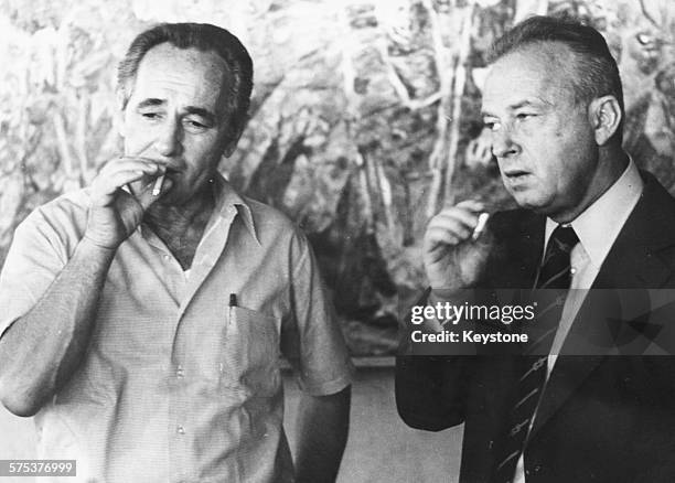 Israeli Prime Minister Yitzhak Rabin and Israeli statesman Shimon Peres smoking cigarettes together, 1975.