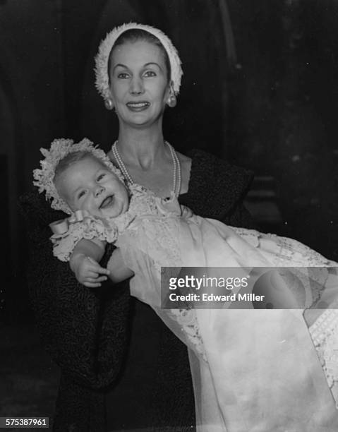 Former model Barbara Goalen, wife of Lloyd's underwriter Nigel Campbell, holding her baby daughter Emma Alexandra after her christening, at St...
