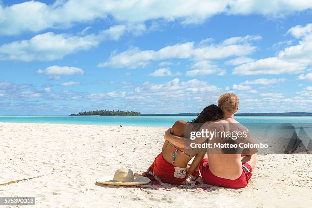 tourist couple embraced on a beach, cook islands - cook islands stock pictures, royalty-free photos & images