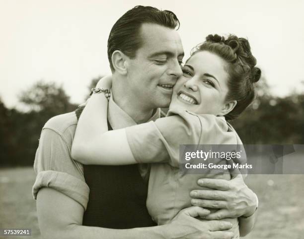 young couple embracing in field, man kissing woman, (b&w) - 1940's stock pictures, royalty-free photos & images