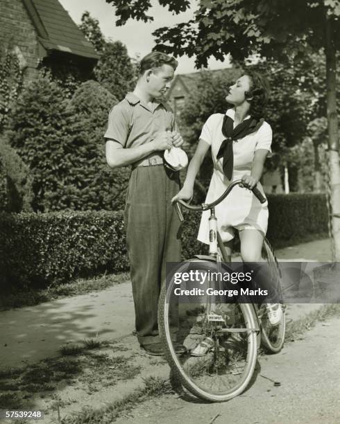 若いカップルで話している通り、女性の自転車、（b &w - 1940s couple ストックフォトと画像