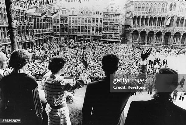 King Baudouin and Queen Fabiola of Belgium waving to the crowds from the balcony of the town hall, at a celebration marking the 25th anniversary of...