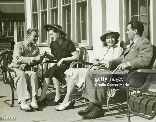 two couples relaxing outside, (b&w) - 1930 stockfoto's en -beelden