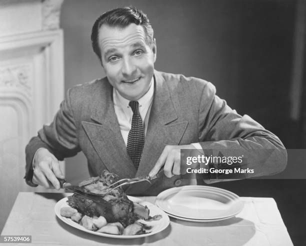 man at table carving roast, (b&w), portrait - funny rooster stockfoto's en -beelden