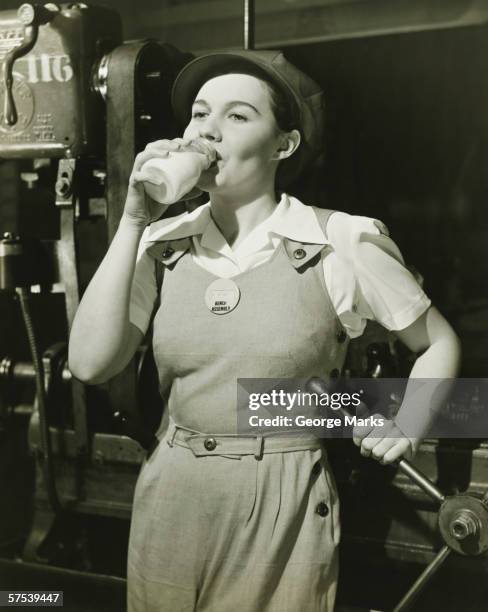 mulher jovem em macacão de pé em torno mecânico - 1930s imagens e fotografias de stock