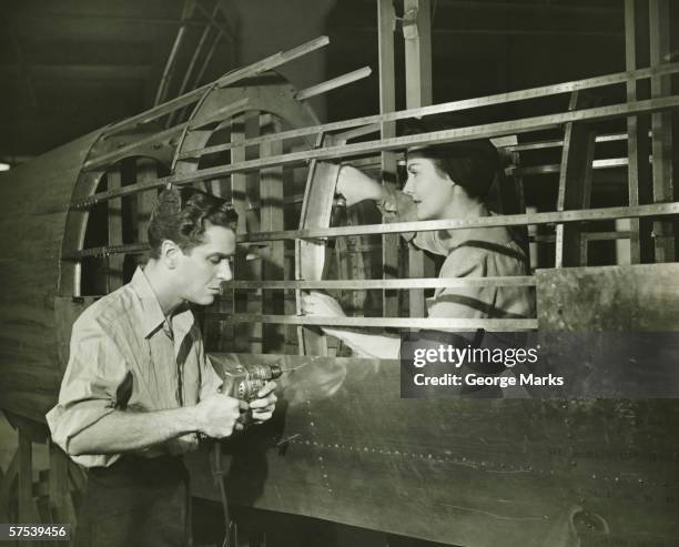 junger mann und frau arbeiten im flugzeug körper in fabrik, (b & w - zweiter weltkrieg stock-fotos und bilder