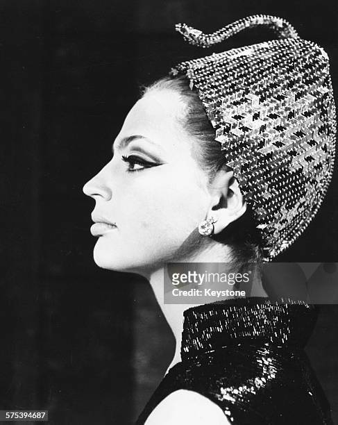 Profile portrait of Princess Ira von Furstenberg wearing a sequin turban, as she appears in her feature film debut 'Matchless', Rome, May 1966.