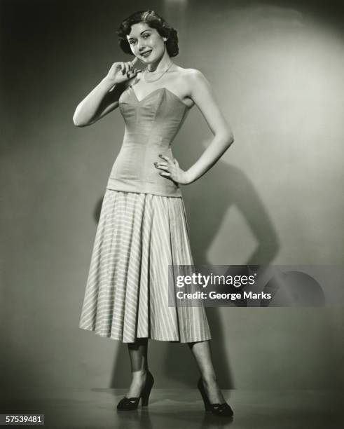 junge frau stehend im studio, lächeln, (b & w - vintage corset stock-fotos und bilder