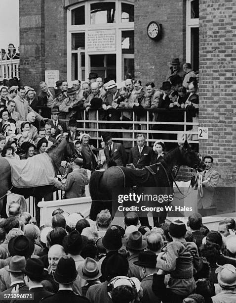 Queen Elizabeth II talking to the Duke of Norfolk as they watch her horse 'Gay Time' , ridden by Gordon Richards, at the Gordon Stakes, Goodwood,...