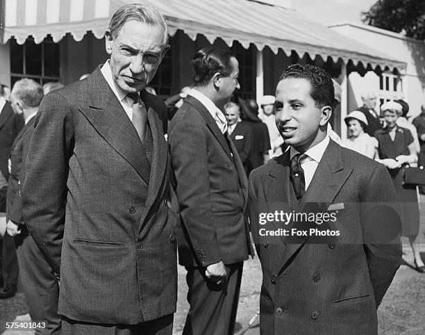 British diplomat Sir John Troutbeck and King Faisal of Iraq, with Crown Prince Abdul Illah in the background, in conversation at a garden party held...