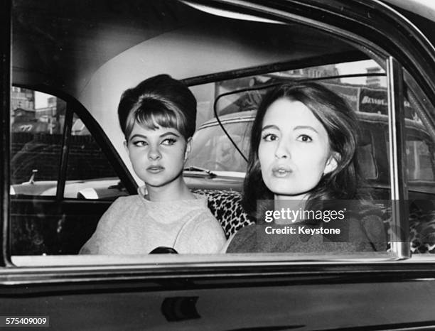 Showgirls Mandy Rice-Davies and Christine Keeler, witnesses in the Profumo Scandal, pictured in the back of a car as they leave court following the...