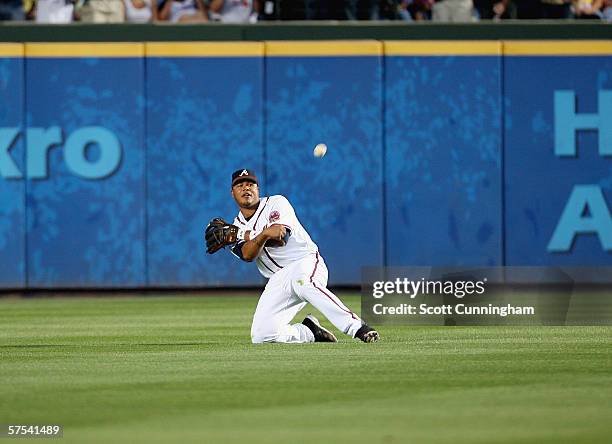 Andruw Jones of the Atlanta Braves throws the ball back to the infield after making a diving catch against the San Diego Padres at Turner Field on...