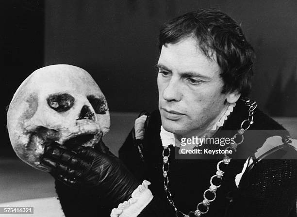 French actor Jean-Louis Trintignant holding the skull of Yorik during a scene from the Shakespeare play 'Hamlet', Paris, circa 1959.