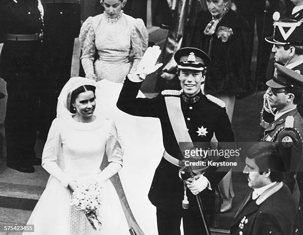 Prince Henri of Luxembourg waving to the crowd, with his bride Maria Theresa, leaving the cathedral following their wedding ceremony, Luxembourg,...
