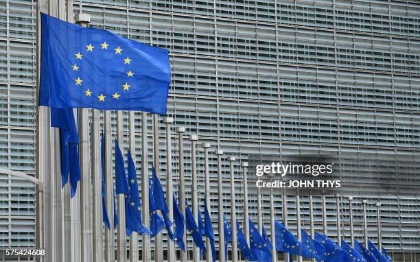 This photo taken on July 15, 2016 shows European Union flags flying at half-mast in front of the European Commission building in Brussels on July 15...