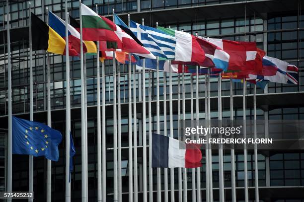 This photo taken on July 15, 2016 shows the French and European Union flags flying at half-mast in front of the European Parliament building in...