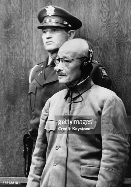 Former Japanese Prime Minister Hideki Tojo, a general of the Imperial Japanese Army during World War Two, wearing translation headphones as he is...