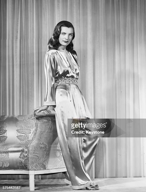 Portrait of actress Ella Raines wearing an ivory, satin jumpsuit, circa 1943.