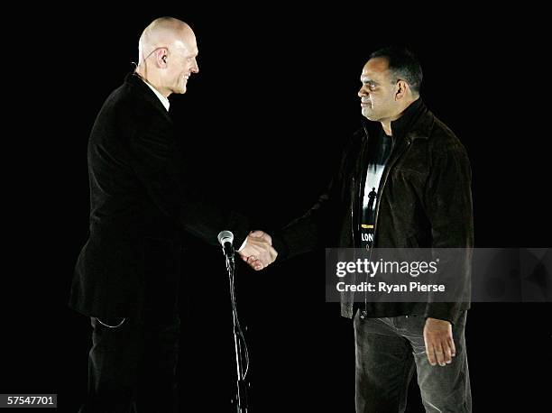 Singer Peter Garrett and former Essendon player Michael Long shake hards as part of the "Dreamtime at the G" match before the round six AFL match...