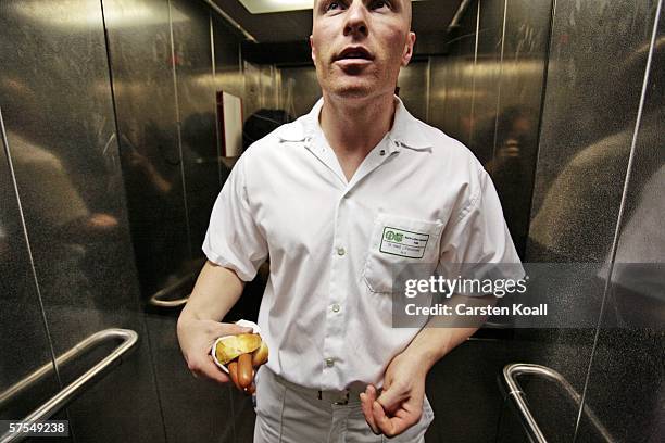 Josef Penzkofer, specialist doctor for casualty surgery, has a short break for a sausage between two surgerys in the clinic for surgery and...