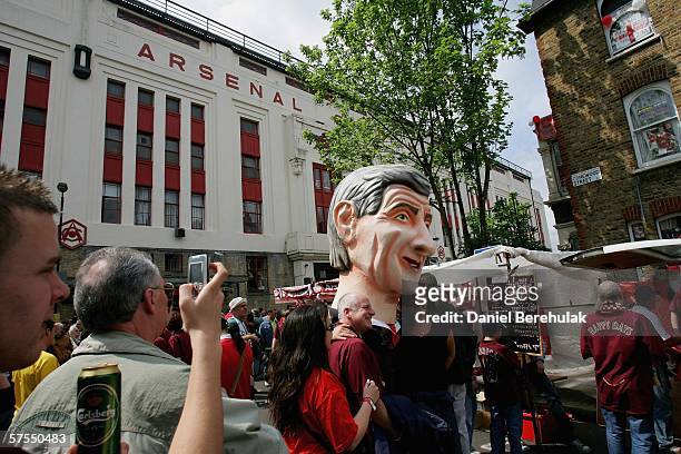 Arsenal fans have a photo with an over-sized head of Arsen Wenger as they arrive to watch the game before the Barclays Premiership match between...