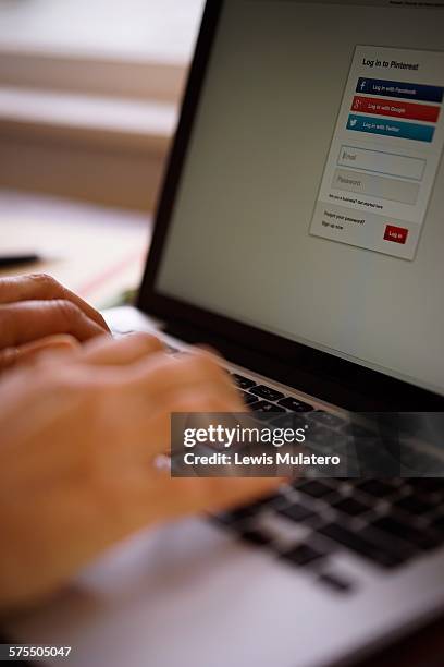 Social media. Female hands using laptop computer to join Pinterest. Pinterest log in page is visible on computer screen.