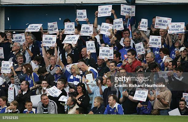 Portsmouth fans hold up signs after their team avoided relegation during the Barclays Premiership match between Portsmouth and Liverpool at Fratton...