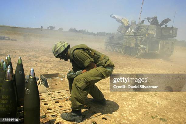 An Israeli army soldier prepares to reload as a 155mm mobile artillery piece launches a shell at Palestinian targets in the Gaza Strip May 8, 2006...