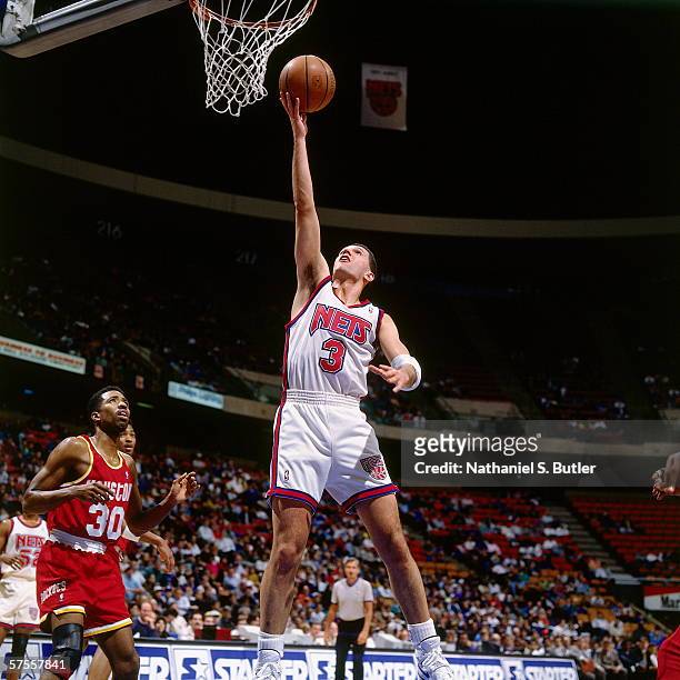 Drazen Petrovic of the New Jersey Nets shoots a layup against Kenny Smith of the Houston Rockets at the Brendan Byrne Arena on January 30, 1993 in...