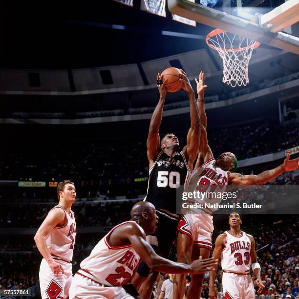 David Robinson of the San Antonio Spurs takes the ball to the basket against Dennis Rodman of the Chicago Bulls at United Center on December 8, 1995...