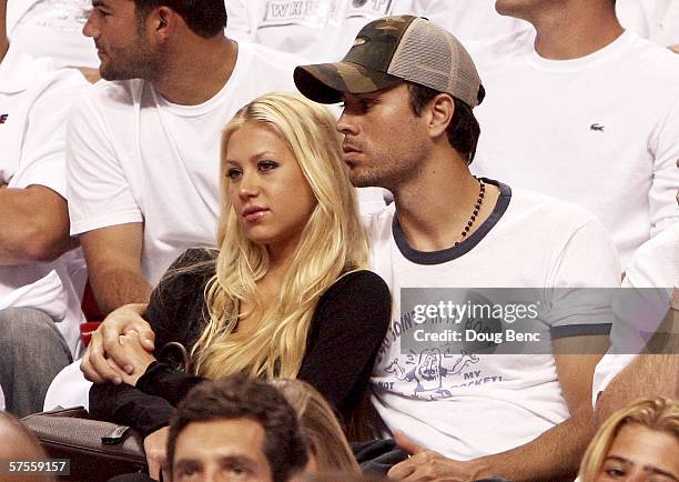 Former Tennis player Anna Kournikova and singer Enrique Iglesias hold each other as they watch the the New Jersey Nets take on the Miami Heat in game...