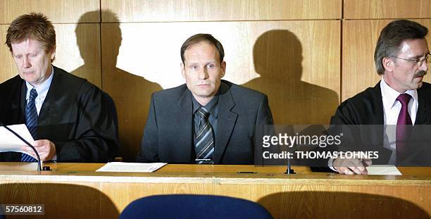 Self-confessed German cannibal Armin Meiwes sits between his advocates Harald Ermel and Joachim Bremer as he waits for the beginning of a session of...