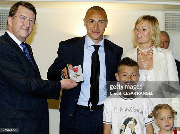Barcelona's Swedish striker Henrik Larsson poses with his wife Magdalena, daughter Janele and son Jordan as he holds the Order of the British Empire...