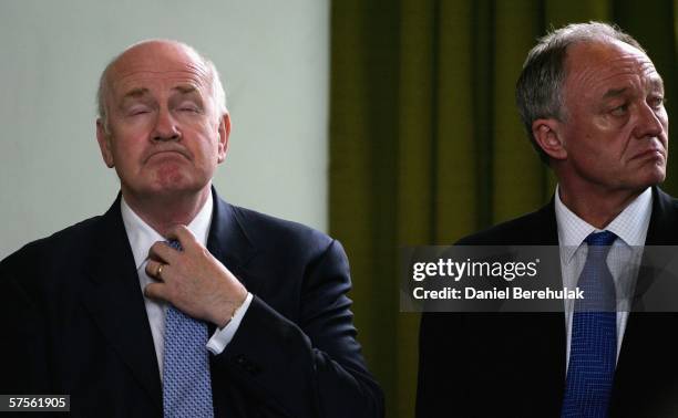 Newly appointed British Home Secretary John Reid adjusts his tie as London Mayor Ken Livingstone looks on during a commendation ceremony on May 9,...