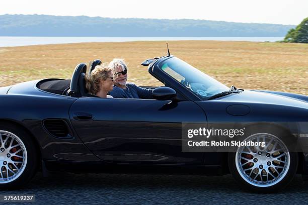 mature man and woman driving in open car - 2015 45 50 stock pictures, royalty-free photos & images