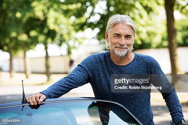 portrait of mature grey haired man leaning on car - man blouse stock pictures, royalty-free photos & images