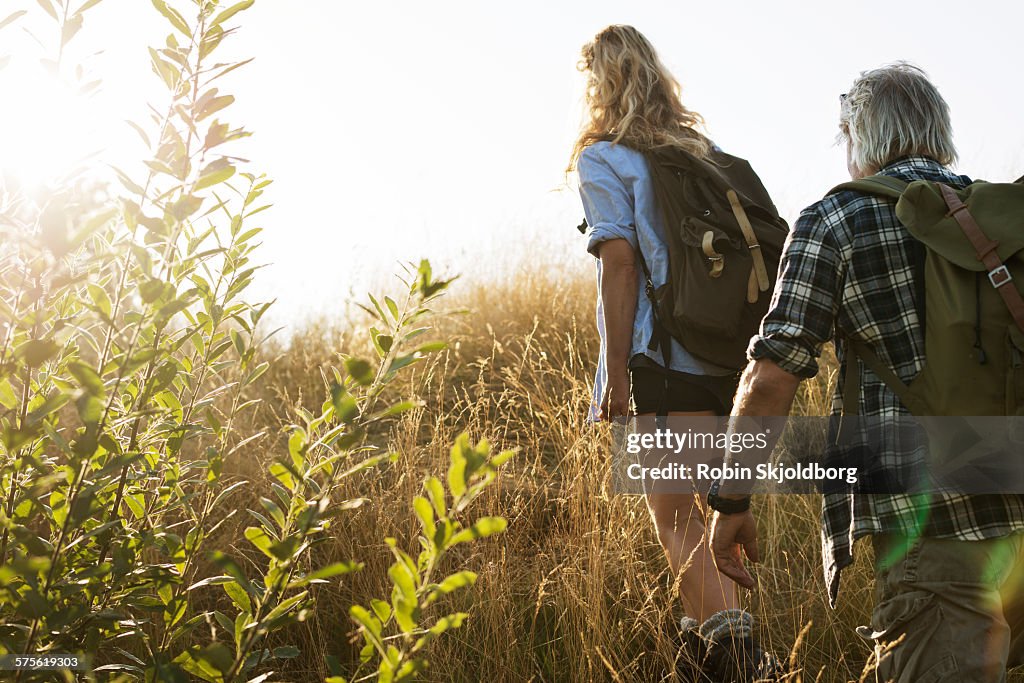 Mature Man and Woman with rucksacks hiking